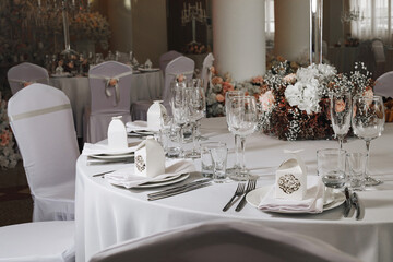tableware Glasses, flower fork, knife served for dinner in restaurant with cozy interior