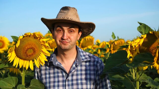 Handsome man farmer rejecting ideas or proposal saying no and nodding his head in sunflowers field