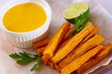 Oven-baked sweet potato fries, with a dipping sauce.