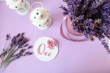 Birthday greeting composition: lanterns, lavender bouquet and inscription, lilac background, place for the inscription, top view