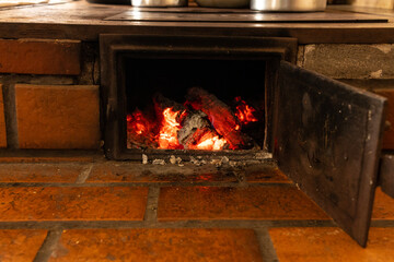 Firewood stove with bricks, highlighting the ember. Black orange color and embers in the center of the image