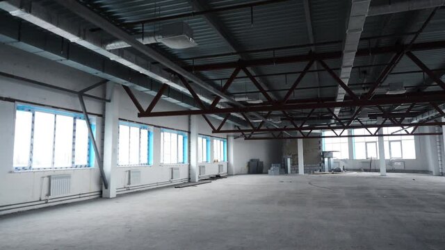 Empty white space for company in new building. Stock footage. Open, empty warehouse with bare walls and steel beams. Investment in real estate for business