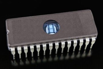 Erasable programmable read-only memory. EPROM chip on black background. Digital integrated circuit...