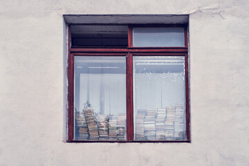 Obraz premium Window of the house with a stack of books on the windowsill library
