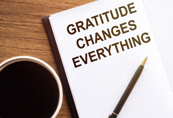 Gratitude changes everything - motivation writing on a notebook on table