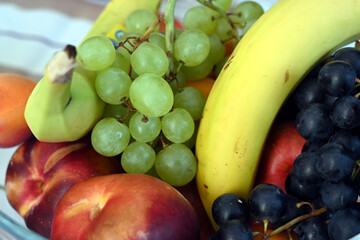 fruit bowl with bananas, grapes, peaches, nectarine and apricot
