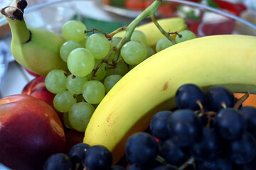 fruit bowl with bananas, grapes, peaches, nectarine and apricot
