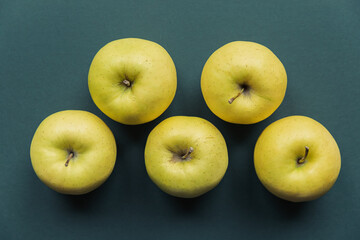 golden delicious apples on a green background