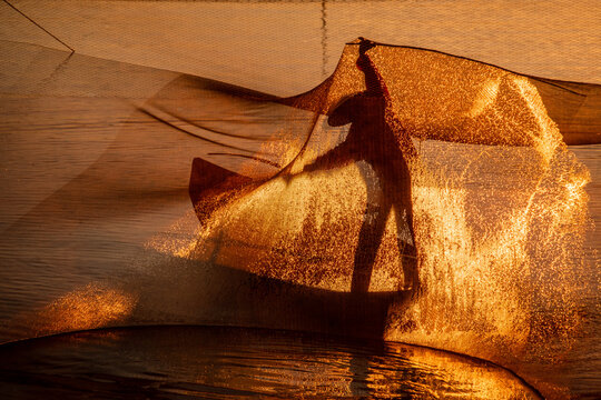 Silhouette of a fisherman checking his nets at sunrise, Vietnam