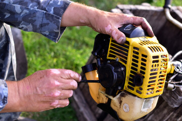 Repair by hand with a screwdriver petrol pumps on the grass