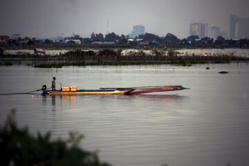 Fisherman on a motor boat on a lake in the evening
