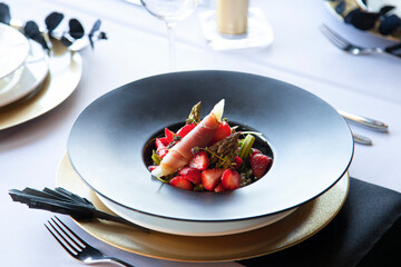 Parma ham with strawberries served in the black bowl