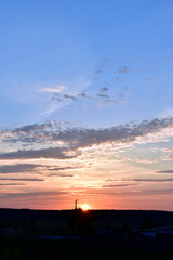 Fototapeta premium Evening sunset landscape orange clouds and a trace of the plane