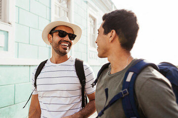 Two happy male tourists walking with backpacks. Travel and love concept in Latin America