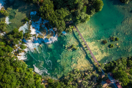 Aerial view of Skradinski Buk waterfall surrounded by trees with turquoise water in Lozovac, Croatia