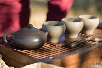 Chinese tea ceremony. Ceramic teapot made of clay and bowls on a wooden background.