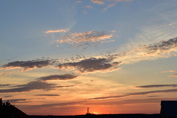 Naklejka premium Evening sunset landscape orange clouds and a trace of the plane