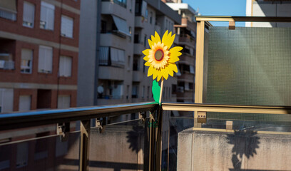 A WINDMILL ATTACHED TO THE BALCONY RAIL