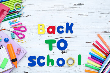 Text Back to School with stationery on white wooden table