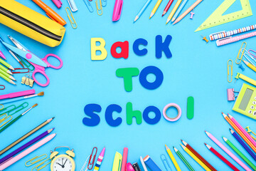Text Back to School with stationery on blue background