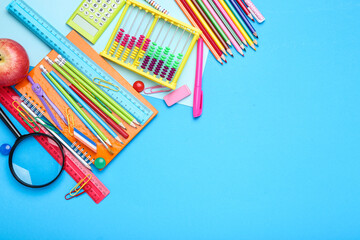 Different school supplies on blue background