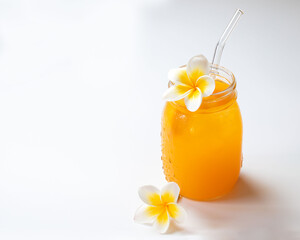 Fresh mango juice in the jar on the white background. Tropical fruit concept. Copy space.