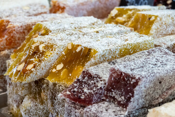Sticks of soft translucent Oriental sweetness. On some sticks, a cut is made to demonstrate the nut as part of the sweetness. Selective focus.