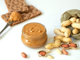 Peanut butter isolated and peanuts in the peel scattered on the white background. 