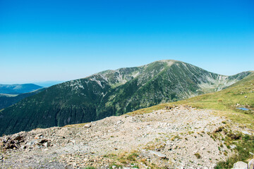Fototapeta premium Beautiful mountain scenery. The tops of the mountains reach the blue sky