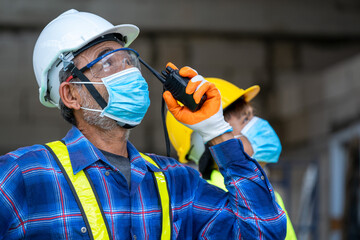 Engineer group wearing protective mask to Protect Against Covid-19 use radio communications to...
