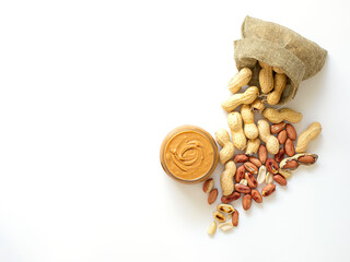 Peanut butter isolated and peanuts in the peel scattered on the white background. Copy space. Top...