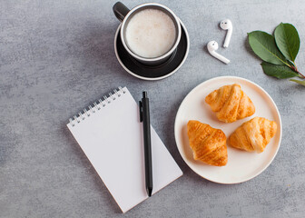 White Notepad, wireless headphones, coffee mug. The concept of online training, work from home, home office. Copy space.