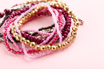 Colorful bracelets on pink background