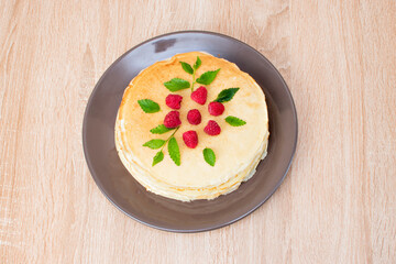 Pancakes with raspberries. Pancakes with raspberries on a brown plate. Pancakes with raspberries on a plate and a wooden board.