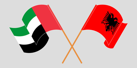 Crossed and waving flags of Albania and the United Arab Emirates