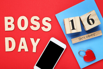 Inscription Boss Day with smartphone and notepad on red background