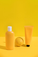 Sunscreen cream bottle and lemon for package mockup design. Minimal summer skin care concept background. Sun protection lotion