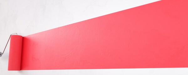 Painting a red line with a paint roller.