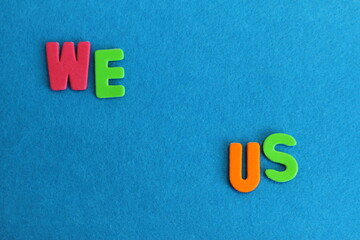 We us lettering, colorful letters on blue textured background, copy space 