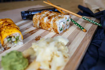 Set of traditional Japanese dishes. Sushi rolls, nigiri, raw salmon, rice, cream cheese, avocado, pickled ginger.