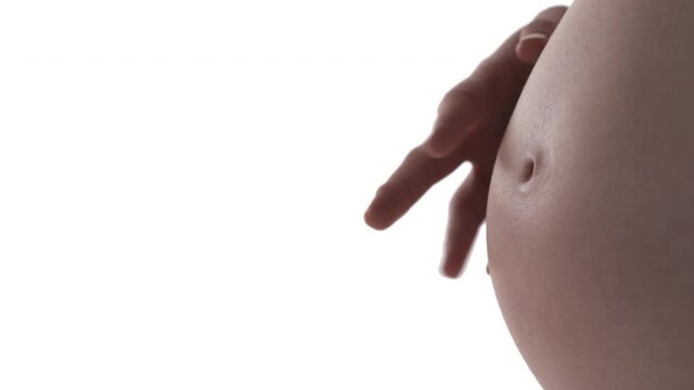 Macro shot of pregnant Caucasian woman's belly. Expecting mother drumming her fingers on tummy. Happy maternity concept. Isolated on white background.