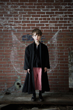 Boy has graffiti wings in an abandoned brick building