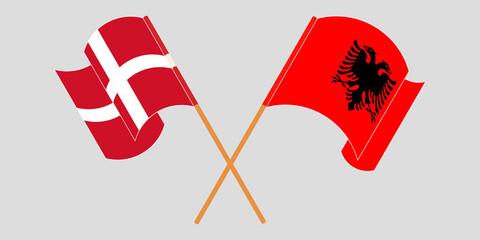 Crossed and waving flags of Albania and Denmark