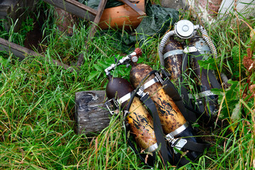 old diving cylinders have completed their operation and lie in the grass near the museum
