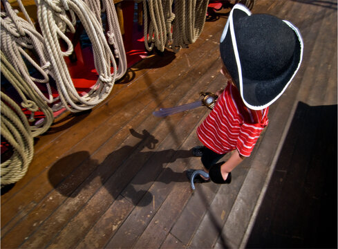 Young boy dressed up as pirate watches his shadow