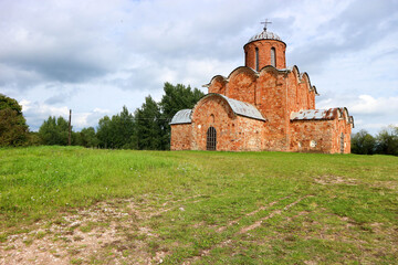 Fototapeta na wymiar Beautiful medieval church of the Savior on Kovalevo with red walls near Velikiy (Great) Novgorod, Russia