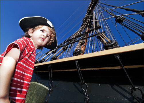 Boy dressed as pirate pretends as he prepares to board his ship