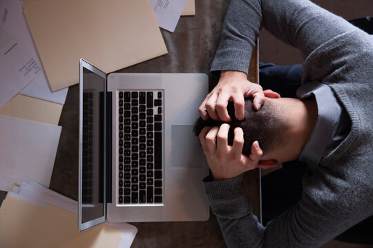 Frustrated male working on laptop at desk