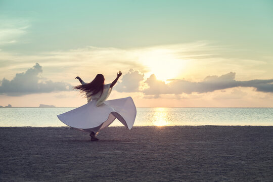 Woman Dancing on the Beach at Sunset