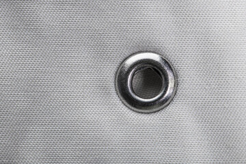 metal grommet on grey raincoat fabric